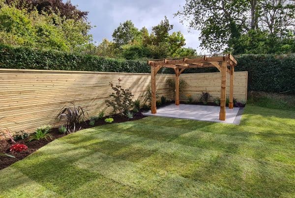 Garden landscaping with a wooden pergola in North Devon by Evergreen Landscaping.